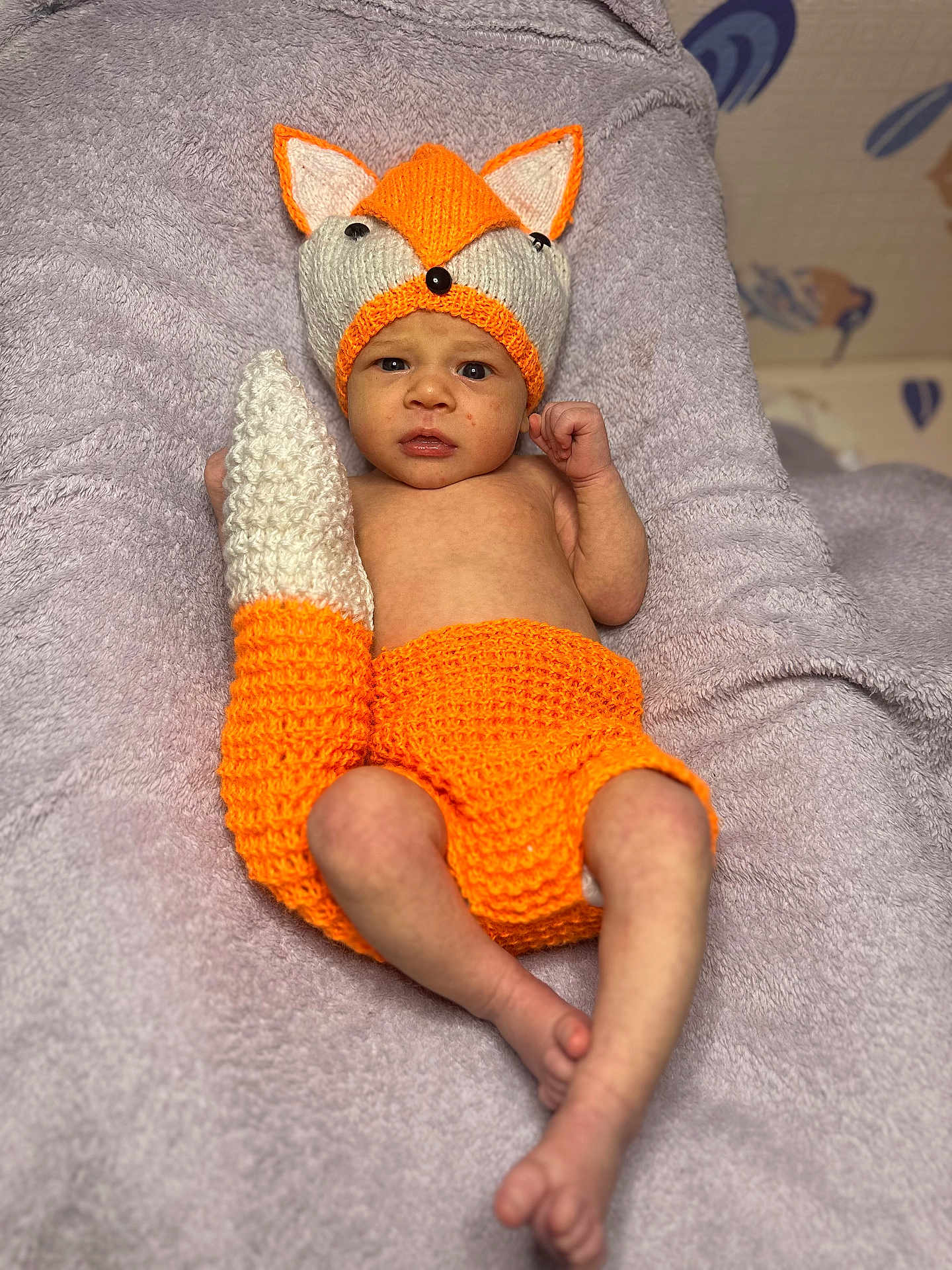 Danylo participe au concours pour gagner de l'argent avec cette photo : baby, newborn, infant, fox_hat, knitted_hat, crochet_tail, orange_clothing, blanket, towel, lying_down, bare_torso, face, eyes_open, hand, feet, soft_texture, cozy, portrait, cute, nursery_background