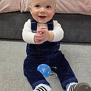 Oakley joined the competition — help win amazing prizes! baby, blanket, carpet, child, clapping, clothing, couch, cute, face, happy, home, indoor, infant, overalls, person, portrait, sitting, smiling, sneakers, young