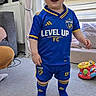 Oakley joined the competition — help win amazing prizes! blue_clothing, carpet, child, curtains, face, floor, furniture, home, indoor, person, playtime, radiator, shorts, smiling, soccer_uniform, socks, standing, toddler, toy, yellow_accents