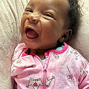 Annaliese joined the competition — help win amazing prizes! baby, child, smiling, laughing, pink_clothing, onesie, crown_pattern, cute, happy, infant, face, head, curly_hair, soft_blanket, texture, portrait, closeup, person, indoors, cozy