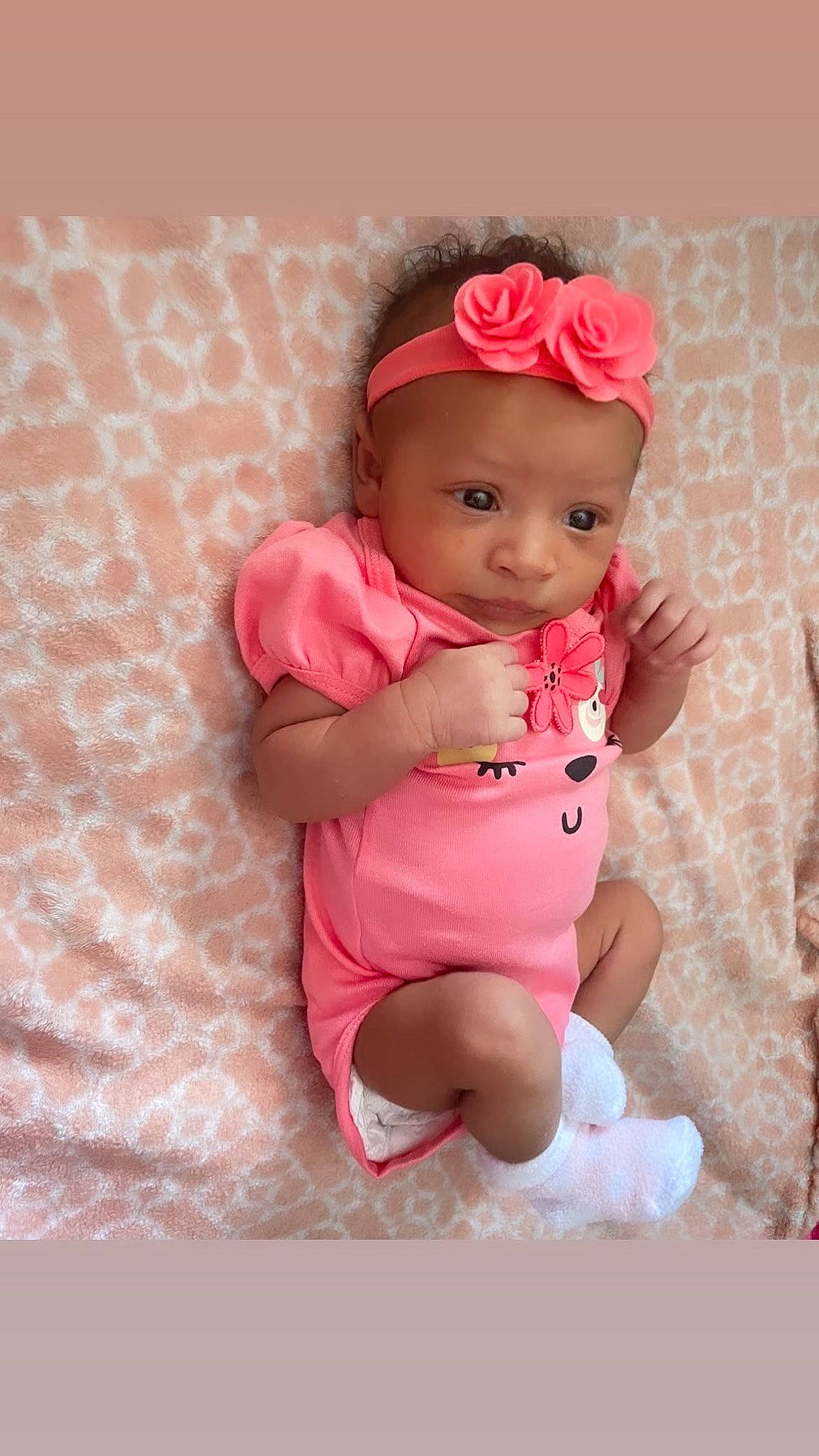 Mia is registered to the contest to win money with this photo: baby, baby_products, baby_toddler_clothing, cheek, child, clothing, comfort, fashion_accessory, hair_accessory, headwear, human_leg, linens, magenta, pattern, peach, person, pink, sitting, skin, sleeve