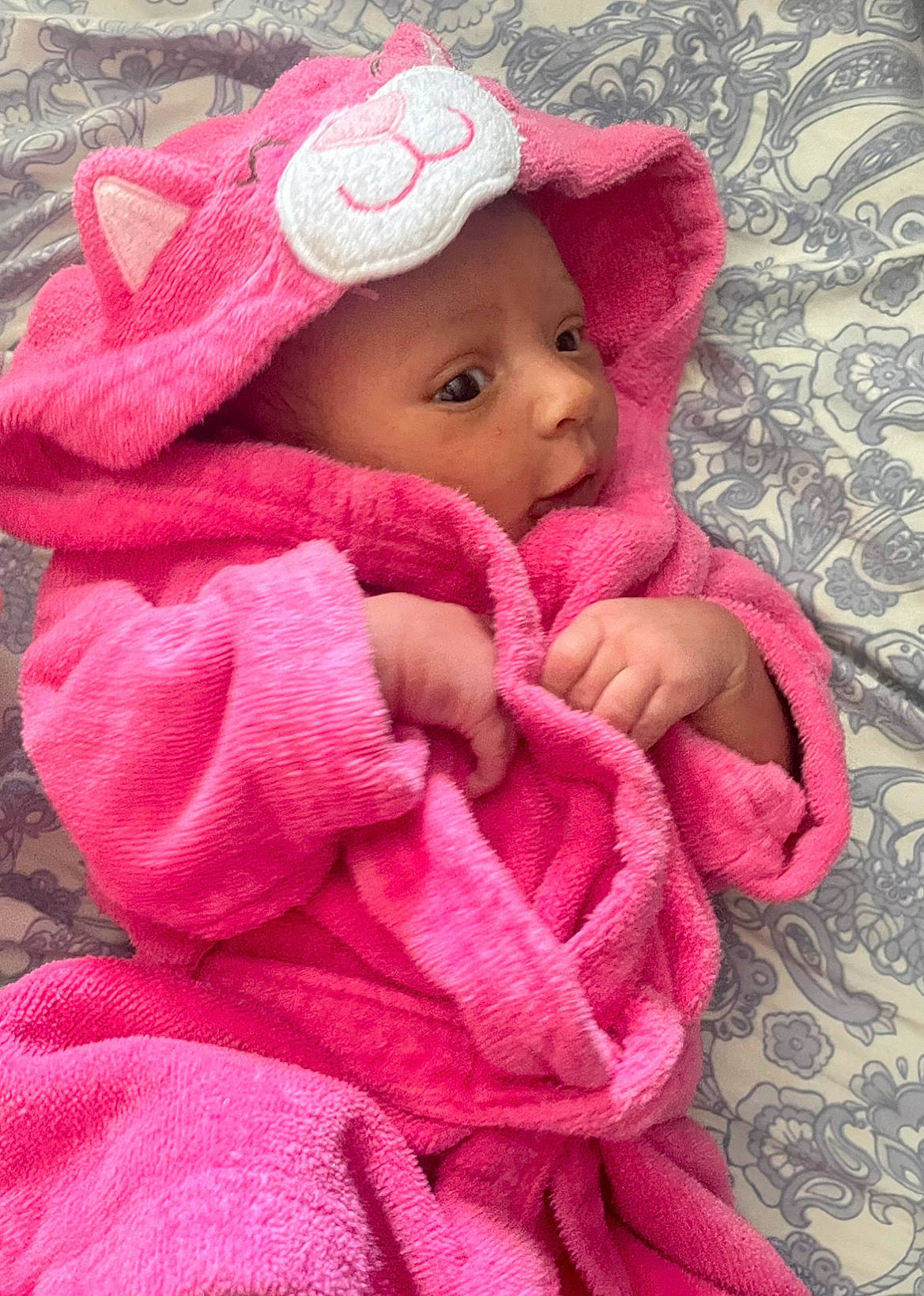 Mia is registered to the contest to win money with this photo: baby, baby_toddler_clothing, cap, cheek, chin, comfort, eye, face, finger, hand, head, headgear, headwear, jacket, lip, magenta, nose, person, pink, skin