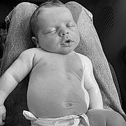 Jager is registered to the contest to win money with this photo: baby, sleeping, diaper, lap, person, skin, hair, peaceful, relaxed, infant, child, monochrome, black_and_white, portrait, casual, indoor, resting, cute, newborn, soft