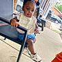 Aulanii joined the competition — help win amazing prizes! toddler, child, outdoor, chair, sneakers, bib, pigtails, hair_beads, brick_wall, porch, concrete_floor, car, parked_car, bottle, person, casual, expression, tongue_out, clothing, seat