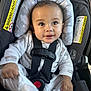 baby, child, car_seat, safety_harness, pajamas, infant, smiling, happy, cute, indoors, seatbelt, face, hands, clothing, head_support, young_child, portrait, person, baby_clothes, comfort