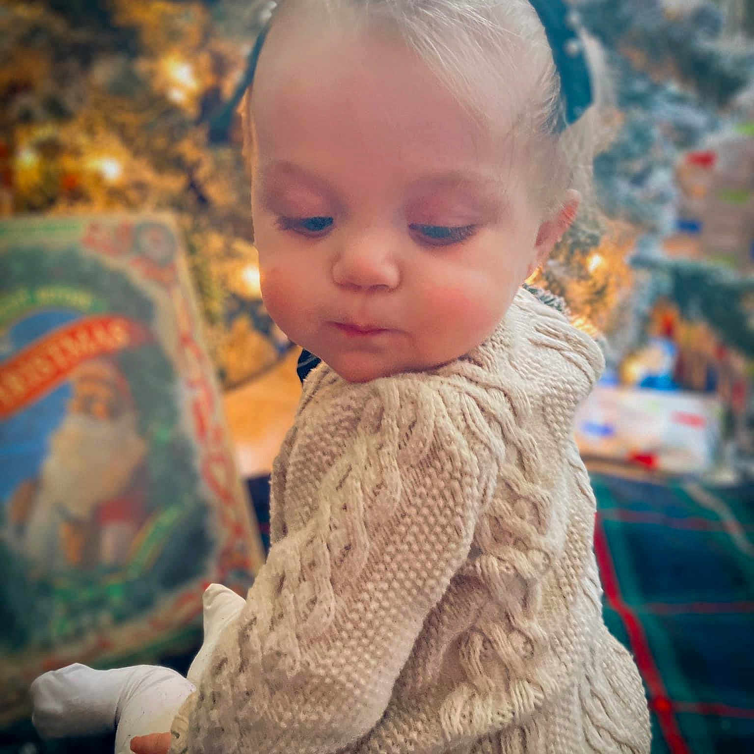 Ezmaria Bonafede is registered to the contest to win money with this photo: baby, brown_hair, child, christmas_ornament, event, facial_expression, fun, grass, happy, holiday, iris, leisure, sitting, skin, standing, toddler, winter, wood, wool, woolen