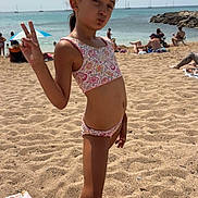 Nelya participe au concours pour gagner de l'argent avec cette photo : barefoot, beach, child, girl, holiday, outdoor, peace_sign, people, posing, relaxing, rock, sand, sea, sky, summer, sunbathers, sunlight, swimsuit, vacation, water