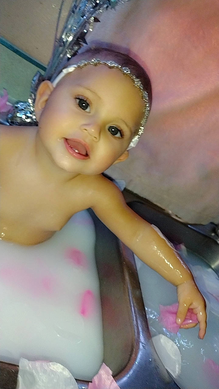 Azaria is registered to the contest to win money with this photo: bathing, cheek, child, eyebrow, eyelash, finger, forehead, fun, hairstyle, happy, head, headpiece, iris, jewellery, lip, nose, person, pink, skin, toddler