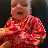 Maizie joined the competition — help win amazing prizes! baby, infant, smiling, pajamas, christmas_pajamas, festive_pattern, cozy, hands, lap, window, blinds, portrait, closeup, cute, newborn, person, fabric, pink_stripes, gingerbread_cookie, happy
