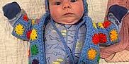 Rosey is registered to the contest to win money with this photo: baby, baby_clothes, blue_onesie, child, colorful_clothing, crocheted_jacket, curious, cute, indoors, infant, knitwear, lying_down, newborn, pacifier, portrait, quilted_blanket, shark_pattern, soft_texture, stillness, wide_eyes