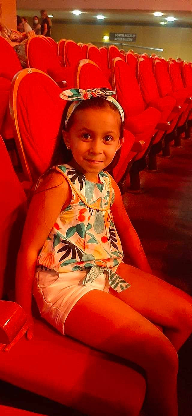 Maïssa participe au concours pour gagner de l'argent avec cette photo : child, event, facial_expression, fun, hairstyle, happy, human_leg, jewellery, joy, leisure, magenta, orange, organ, people, person, red, sitting, skin, smile, thigh