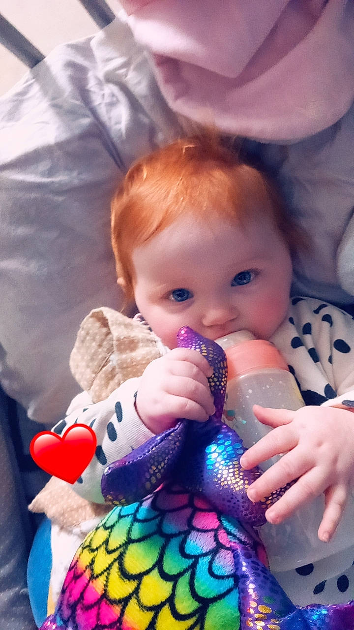 Evy a rejoint le concours — aidez-le/la à gagner de superbes lots ! baby, baby_toddler_clothing, cheek, child, comfort, drinkware, finger, fun, hand, happy, human_body, iris, nail, nose, organ, people, person, pink, plastic_bottle, skin