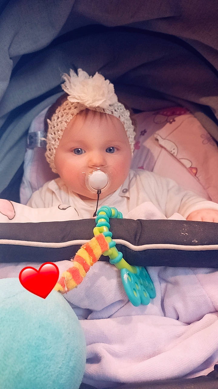 Evy a rejoint le concours — aidez-le/la à gagner de superbes lots ! baby, baby_products, baby_toddler_clothing, balloon, child, event, eye, fun, happy, headband, headgear, headpiece, human_body, iris, mouth, nose, person, pink, sitting, skin