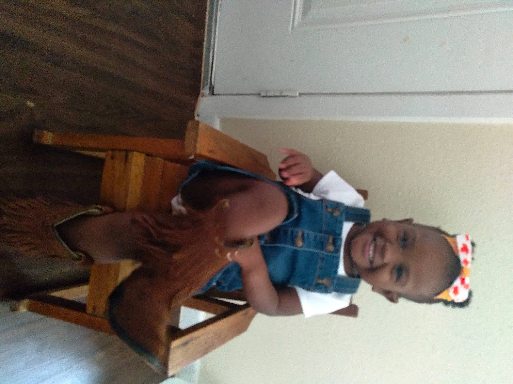 Noah is registered to the contest to win money with this photo: child, comfort, elbow, flooring, fun, hardwood, hat, human_leg, joy, knee, leisure, lumber, person, room, shorts, smile, t_shirt, table, thigh, toddler