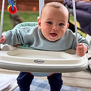 Haiden joined the competition — help win amazing prizes! baby, swing, outdoor, toy, happy, child, smiling, clothing, face, person, play, seat, fabric, sock, hand, wood, fence, furniture, background, blanket