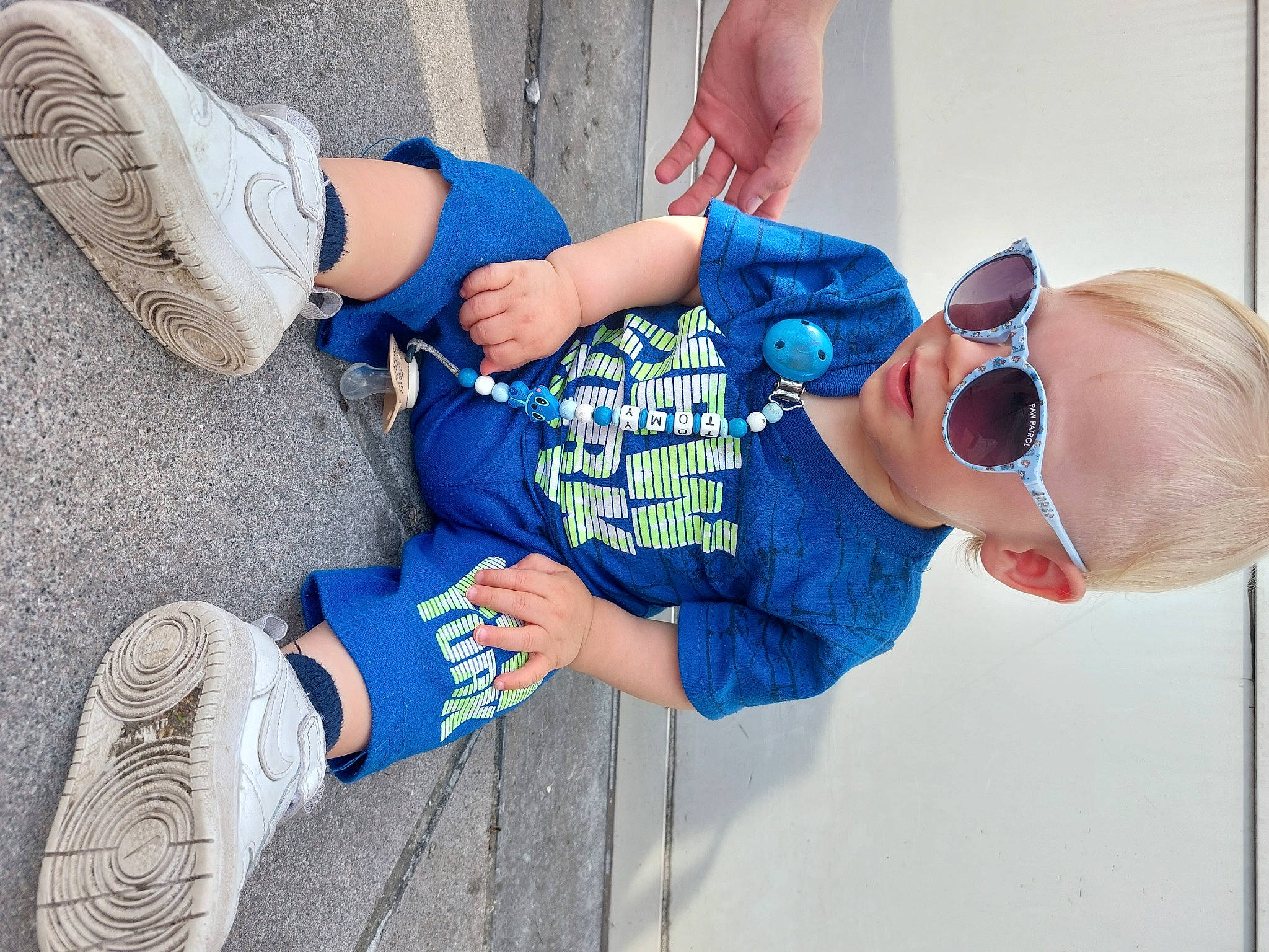 Tomy participe au concours pour gagner de l'argent avec cette photo : arm, azure, cool, electric_blue, finger, gesture, goggles, hand, hat, human_body, human_leg, joint, leg, outdoor_shoe, person, product, sneakers, sunglasses, thigh, toddler