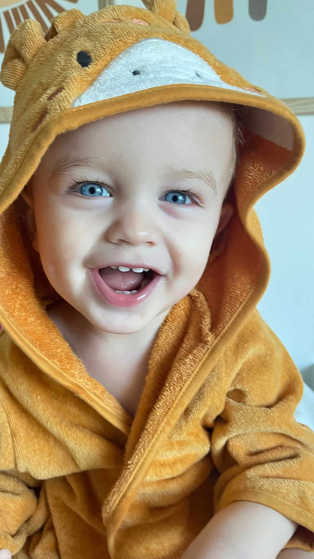 Roméo a rejoint le concours — aidez-le/la à gagner de superbes lots ! toddler, child, smiling, blue_eyes, hooded_robe, orange_robe, animal_hood, cute, happy, indoor, portrait, baby, soft_texture, warm_clothing, closeup, face, expression, joyful, small_teeth, cozy