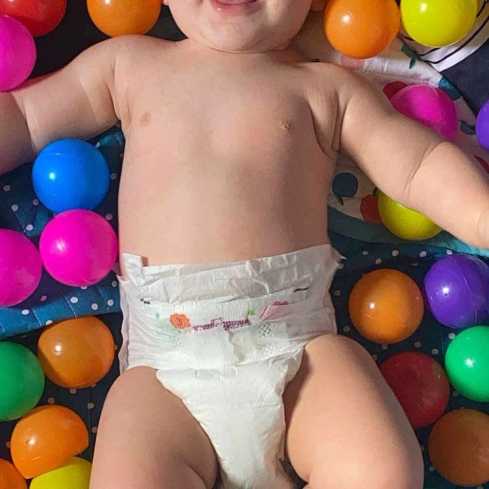 Noah participe au concours pour gagner de l'argent avec cette photo : accessories, baby, babylaughing, balloon, clothing, diaper, face, formalwear, happy, head, laughing, person, photography, portrait, shorts, sitting, smile, standing, summer, swimwear