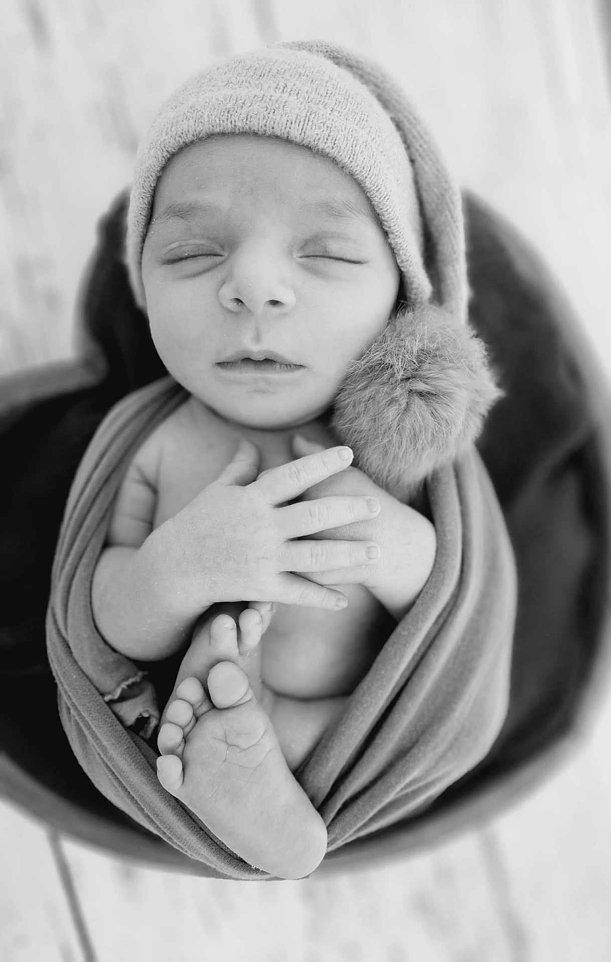 Marius a rejoint le concours — aidez-le/la à gagner de superbes lots ! newborn, baby, infant, sleeping, hat, pompom, swaddle, blanket, feet, hands, portrait, black_and_white, monochrome, closeup, cozy, soft_texture, bucket, wooden_floor, studio_photography, peaceful