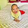 baby, bed, bedding, blanket, child, comforter, face, furniture, happy, indoor, infant, person, portrait, red_pants, smiling, yellow_bib, young_child, photography, room, wall