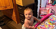 Anthony joined the competition — help win amazing prizes! baby, bed, cardboard_boxes, child, closet, clothing, colorful_bedspread, curious, diaper, furniture, indoor, person, plush_frog, room, standing, storage_drawer, stuffed_animal, toddler, toy, wooden_floor