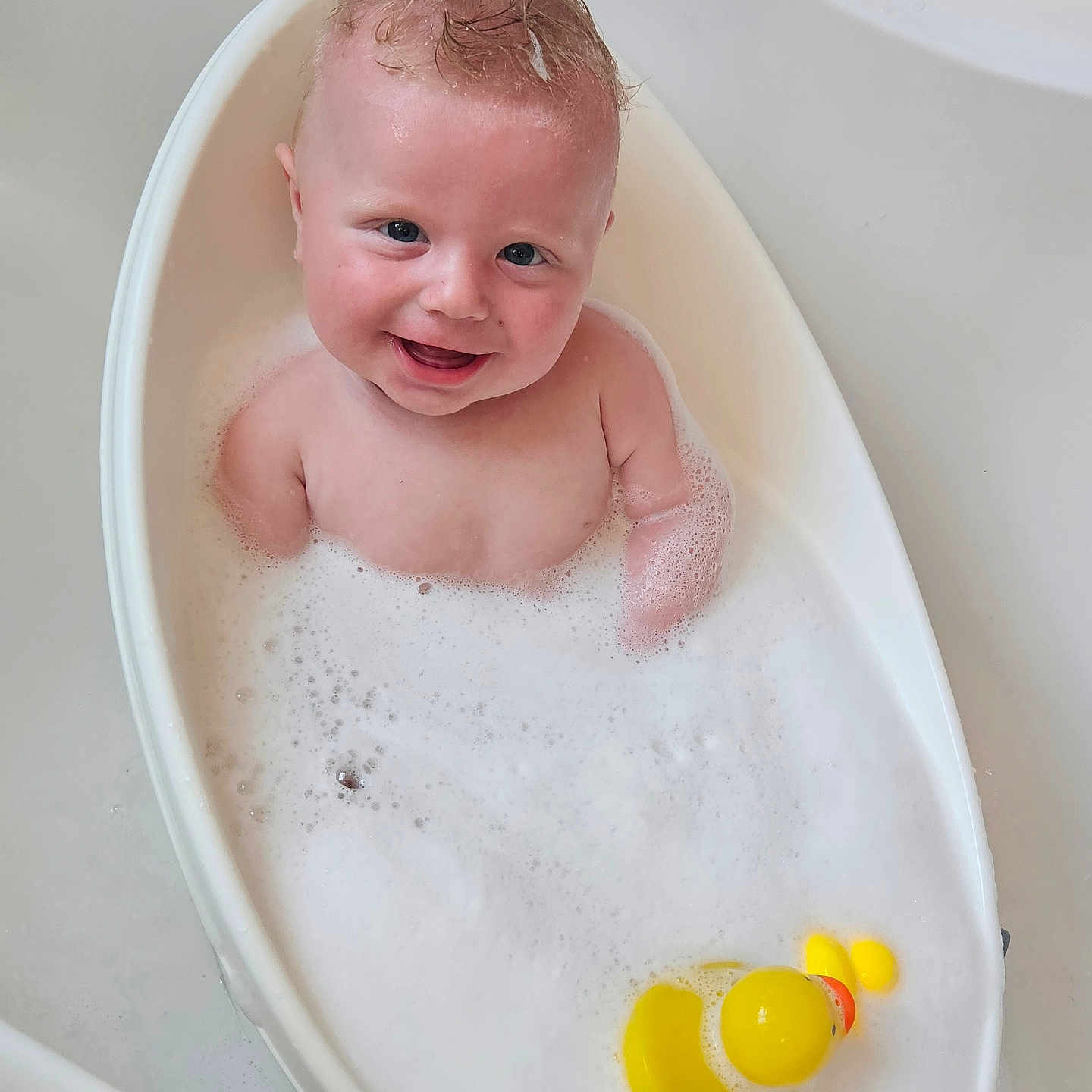 Toby is registered to the contest to win money with this photo: baby, bath, bathtub, bubble_bath, child, clean, cute, foam, happy, human, infant, moawk_hair, playful, rubber_duck, skin, smiling, splash, wash, water, white_tub