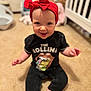 baby, child, smiling, red_headband, black_clothing, rolling_stones_tshirt, carpet, nursery, crib, toys, indoor, sitting, happy, cute, infant, person, headwear, expression, floor, childhood