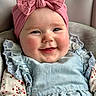 Emilia is registered to the contest to win money with this photo: baby, child, smile, headband, pink_bow, blue_dress, ruffles, floral_pattern, face, cheeks, portrait, happy, infant, cute, clothing, sitting, indoors, person, young_child, closeup