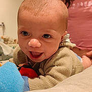 émeric participe au concours pour gagner de l'argent avec cette photo : baby, smiling, infant, toy, bed, sweater, person, indoor, child, happy, face, head, clothing, cute, closeup, portrait, skin, hand, bright, warm