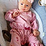 baby, infant, child, portrait, sitting, rocker, pink_outfit, heart_pattern, flower_headband, blue_eyes, wide_eyed, indoors, nursery, striped_fabric, clothing, headband, happy, face, photography, safe