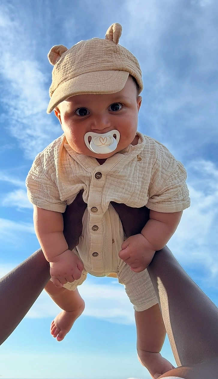 William a rejoint le concours — aidez-le/la à gagner de superbes lots ! baby, child, pacifier, hat, cap, outdoor, sky, blue_sky, clouds, hands, cute, infant, clothing, fingers, face, portrait, flying, playful, person, holding