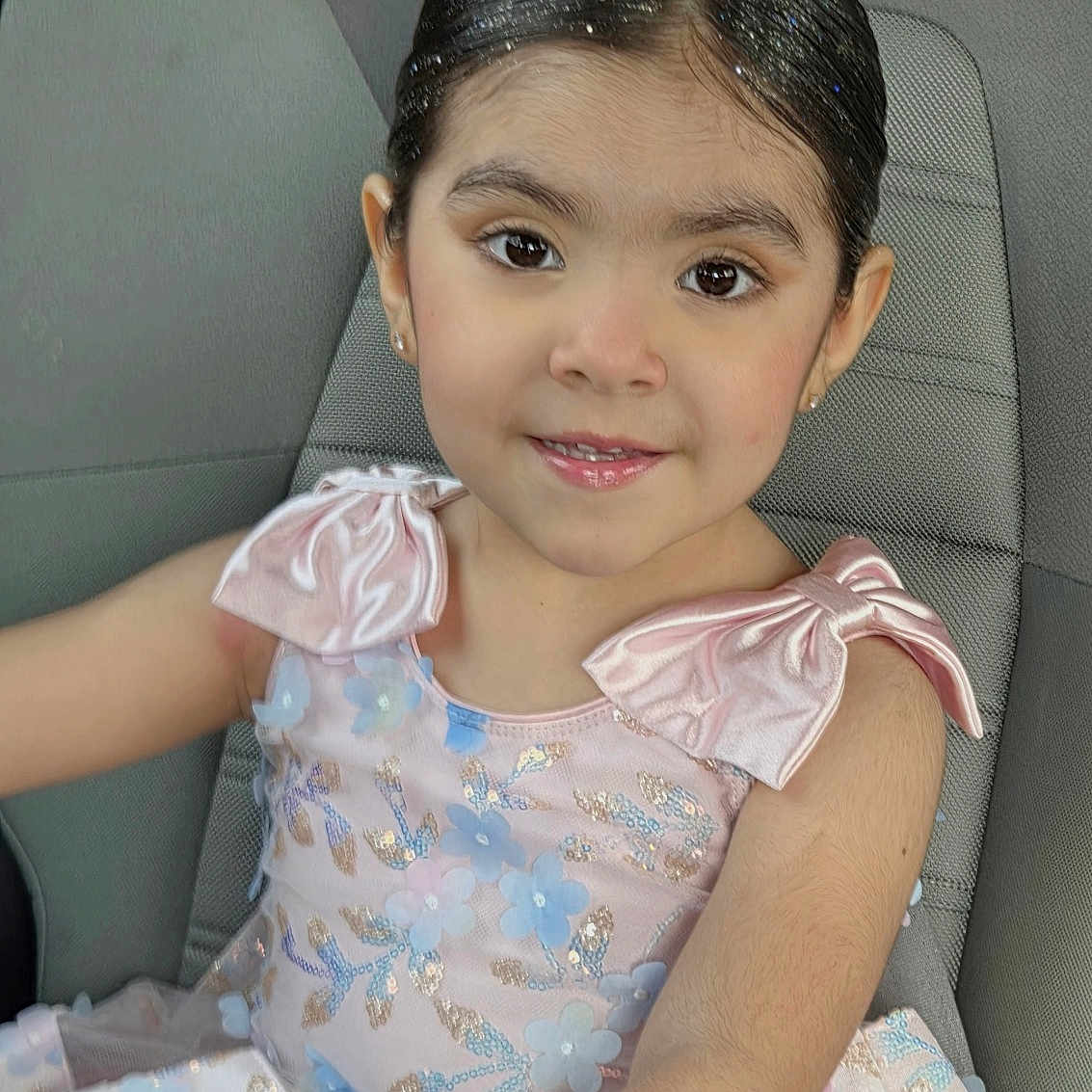 Andrea is registered to the contest to win money with this photo: bows, car_interior, car_seat, child, child_seat, cute, face, fashion, girl, glitter, hair, happy, indoor, person, pink_dress, portrait, seatbelt, sitting, smile, young