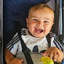 toddler, child, smiling, happy, stroller, toy, yellow_toy, white_shirt, navy_stripes, seatbelt, baby, infant, cute, joyful, portrait, face, hand, clothing, baby_toy, childhood