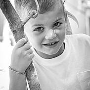 Elio a rejoint le concours — aidez-le/la à gagner de superbes lots ! child, boy, portrait, black_and_white, smile, tree, branch, outdoor, nature, young, face, expression, hand, short_hair, casual_clothing, bracelet, close_up, monochrome, light, shadow