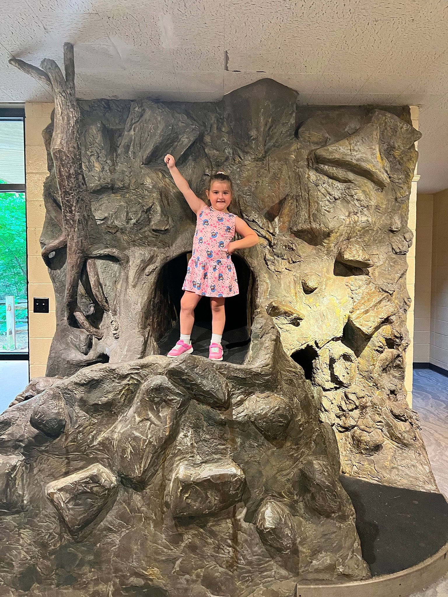 Sarai is registered to the contest to win money with this photo: art, child, font, fun, joy, leisure, person, rock, shorts, standing, t_shirt, temple, textile, toddler, tourism, travel, tree, trunk, vacation, visual_arts