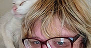 Angel is registered to the contest to win money with this photo: blonde_hair, casual, cat, close_up, companion, cute, face, feline, friendly, glasses, happy, human, indoor, person, pet, portrait, relaxed, shoulder, smiling, white_cat