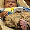 baby, child, smiling, board_book, colors, rainbow, fuzzy_pants, barefoot, feet, cushion, seat, indoor, person, happy, reading, cozy, cute, hand, infant, portrait