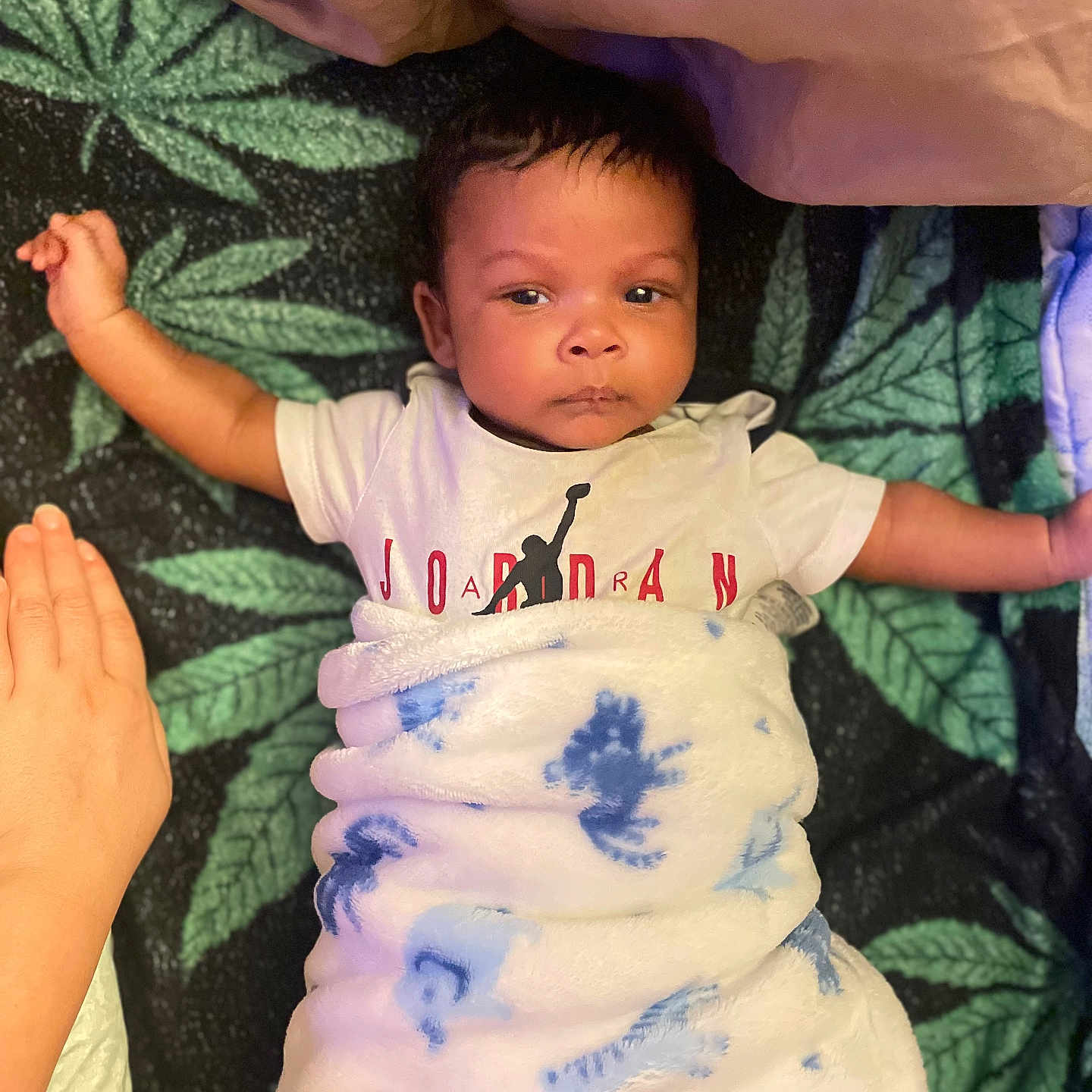 Messiah is registered to the contest to win money with this photo: baby, blanket, child, clothing, comfort, cute, face, hand, indoor, infant, leaf_pattern, lying_down, peaceful, person, portrait, resting, soft_texture, tshirt, wrapped, young