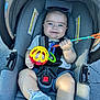 Dylan joined the competition — help win amazing prizes! baby, car_seat, toy, smiling, sunglasses, sneakers, child, infant, seatbelt, outdoor, happy, person, clothing, footwear, hand, face, headwear, play, cute, toddler