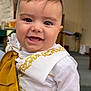 Dylan is registered to the contest to win money with this photo: baby, child, smiling, face, white_clothing, gold_embroidery, indoor, church, religious, altar, cross, portrait, cute, happy, infant, person, celebration, formal_wear, closeup, headshot