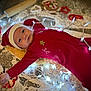 Rylin is registered to the contest to win money with this photo: baby, infant, red_onesie, santa_hat, christmas_lights, cookie_cutters, flour, baking, holiday, festive, floor, cute, face, lights, decorations, winter, indoors, child, smiling, holiday_theme