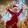 baby, infant, christmas, holiday, red_onesie, santa_hat, flour, wooden_floor, gingerbread_cookies, cookie_cutters, rolling_pin, christmas_lights, festive, smiling, happy, holiday_baking, indoors, cute, celebration, child