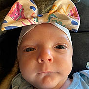 Maci Kay York is registered to the contest to win money with this photo: baby, infant, headband, bow, face, eyes, clothing, portrait, closeup, cute, child, newborn, soft_light, indoors, person, skin, expression, apparel, young, headwear