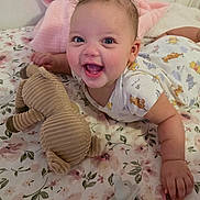 Lily-Rose joined the competition — help win amazing prizes! baby, infant, smiling, laughing, tummy_time, onesie, stuffed_animal, plush_toy, pacifier, bedding, blanket, floral_sheet, nursery, cute, happy, chubby_cheeks, hand, eyes, portrait, toy