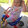 Skylar is registered to the contest to win money with this photo: child, toddler, tricycle, outdoor, blonde_hair, pouting, minnie_mouse, shirt, colorful, crocs, footwear, concrete, sunlight, play, toy, summer, casual_clothing, expression, person, funny_face