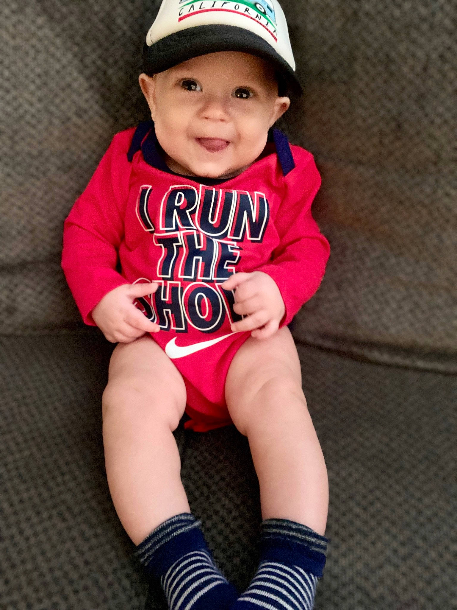 Jaxtyn is registered to the contest to win money with this photo: baby_toddler_clothing, baseball_cap, cap, clothing, cool, eye, face, finger, happy, hat, headgear, headwear, human_body, joy, knee, leg, person, pink, shorts, sleeve