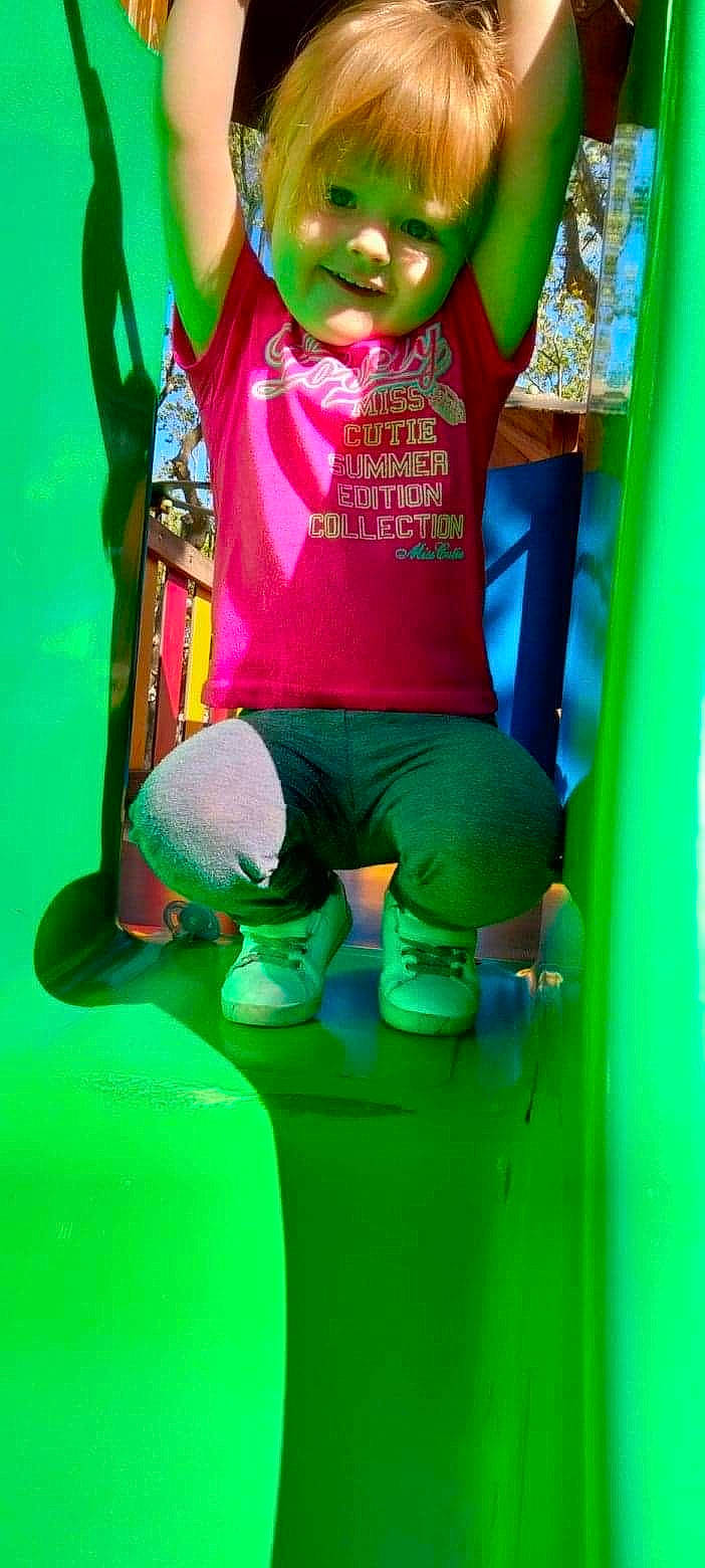 Inaya a rejoint le concours — aidez-le/la à gagner de superbes lots ! baby_toddler_clothing, child, fun, grass, happy, human_leg, leisure, magenta, outdoor_play_equipment, person, pink, plant, playground_slide, recreation, red, shorts, sleeve, swing, t_shirt, toddler