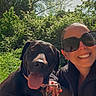 Pina a rejoint le concours — aidez-le/la à gagner de superbes lots ! dog, black_dog, woman, selfie, outdoor, sunny, greenery, trees, smiling, sunglasses, leash, happy, nature, portrait, walking, casual_clothing, daytime, tongue_out, pet, companionship