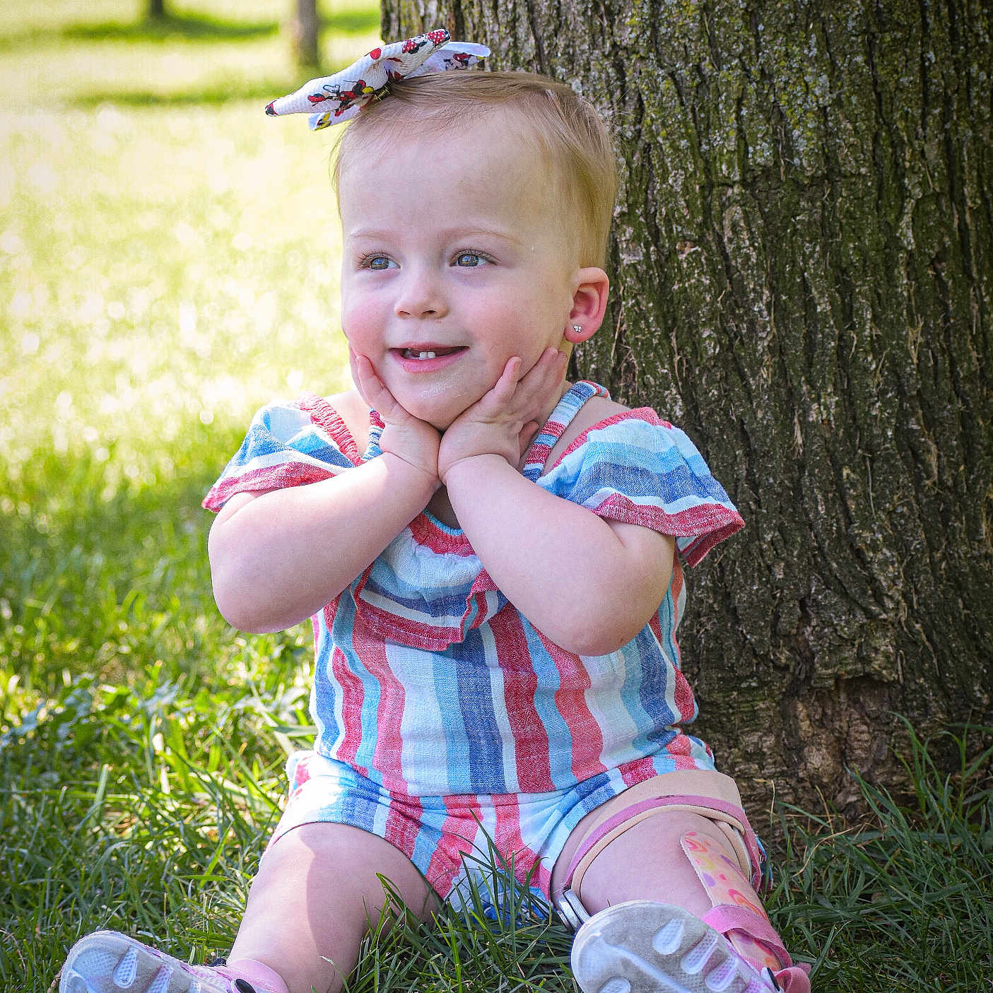 Josephine is registered to the contest to win money with this photo: baby, bodypart, clothing, face, finger, footwear, grass, hand, head, lawn, person, photography, plant, portrait, runningshoe, sandal, shoe, sitting, sneaker, tree
