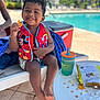 Amir joined the competition — help win amazing prizes! child, toddler, smile, life_vest, mickey_mouse, snack, pool, outdoor, table, drink, chips, lounge_chair, sunny, happy, food, foot, blue_towel, cooler, curly_hair, casual